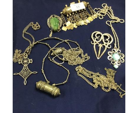A mixed lot of white metal and metal Eastern jewellery including brooches, pendants, chains, jade style carved mounted brooch