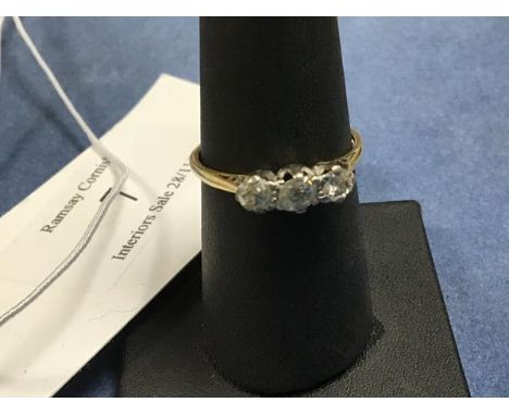 A three stone diamond ring on unmarked yellow metal band (O) (2.1g)