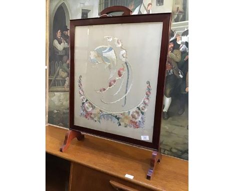 A 20thc. firescreen, the mahogany frame enclosing a silk woven panel depicting an exotic bird, on tressle style supports (80c