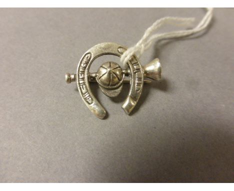 Silver Brooch in the form of Horse Shoe, Hunting Horn and Jockey Cap