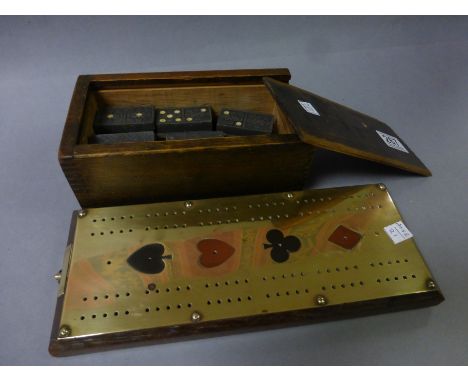A good quality brass and oak cribbage board, plus a boxed set of dominoes