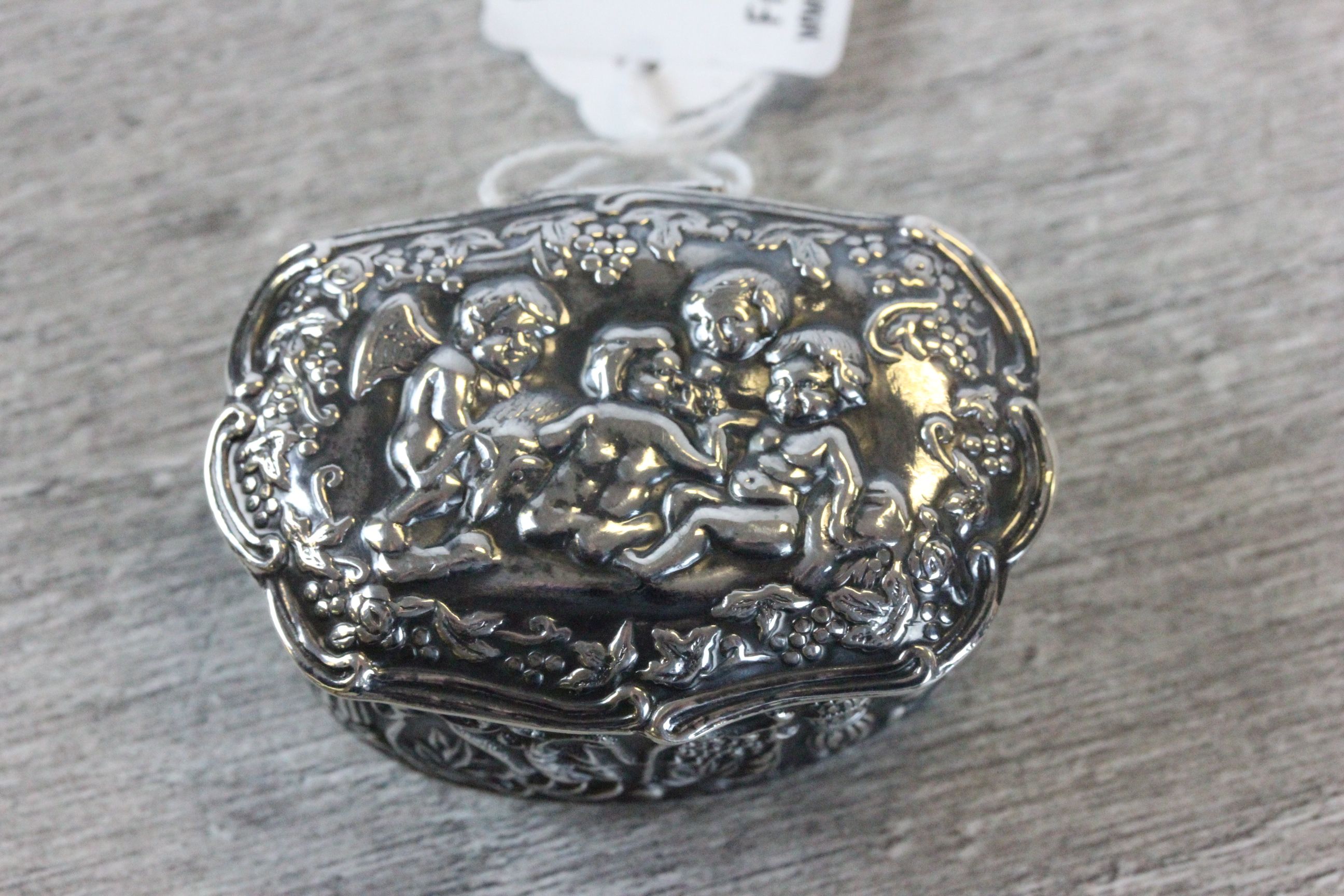 A silver ring box with embossed decoration