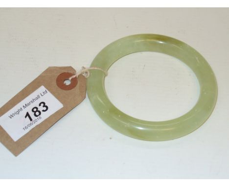 A jade bangle, of typical light green colour, with white fleck and darker green patches throughout, with a small crack to one
