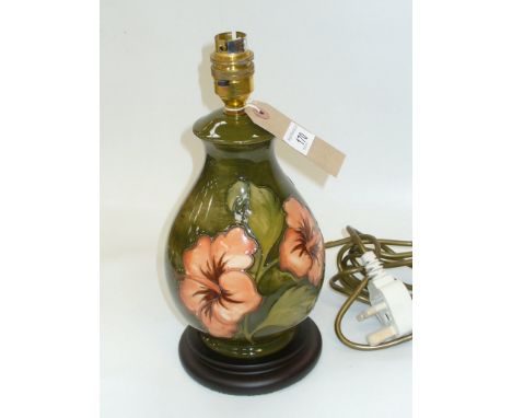 A Moorcroft tube lined coral hibiscus baluster vase shaped table lamp , green ground.