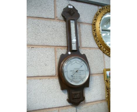 An Early 20th Century oak cased banjo wall barometer with a  silvered dial signed " The Wilson forecast barometer" .