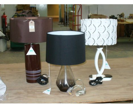 A Cylindrical ceramic table lamp  and a glass bottle shaped table lamp c/w shades (2)

*Please note that this lot is subject 