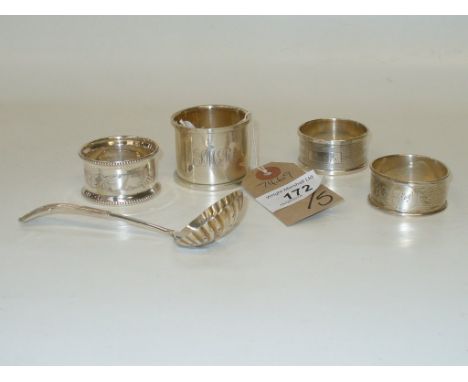Four assorted silver napkin rings and a silver caddy spoon. (5)