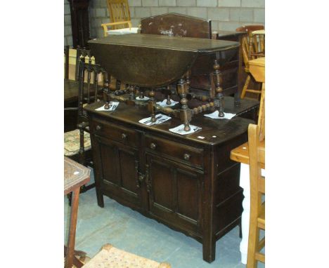 An Ercol elm sideboard with two drawers over two cupboard doors  and an Ercol elm drop leaf coffee table. (2)