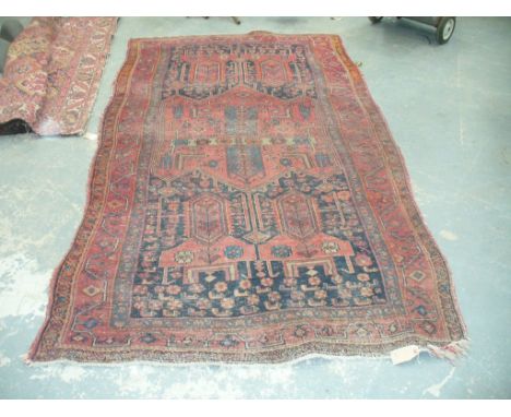 A Qashqai style rug
On a predominantly ruby red ground, the central field with varying geometric patterns and lozenges, ivory