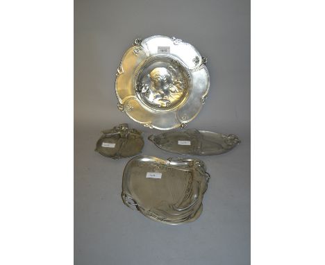 Arte Nouveau pewter dish decorated in relief with a portrait of a lady together with three similar smaller dishes 