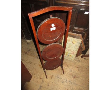 Edwardian mahogany three tier folding cakestand and a 20th Century mahogany framed firescreen with floral woolwork insert 