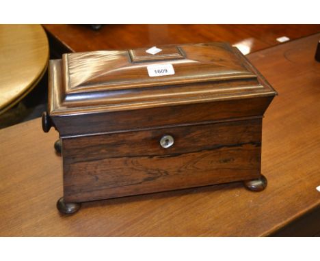 19th Century rosewood sarcophagus shaped tea caddy, the hinged cover enclosing a three division interior with cut glass blend