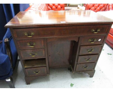 Reproduction mahogany and crossbanded kneehole desk with a long drawer above a cupboard door flanked by eight small drawers o