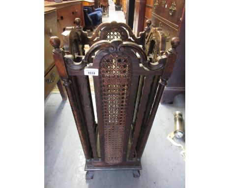 20th Century oak four division stick stand with carved decoration and cane work panels on shaped supports, 13ins square, 30in