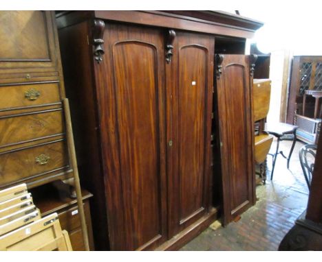 19th Century mahogany three door wardrobe, the moulded cornice above long panel doors with carved details and fitted interior