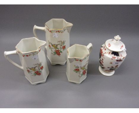 20th Century Coalport Hong Kong pattern covered vase together with a graduated set of three pottery milk jugs 