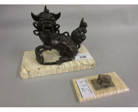 Chinese dark patinated bronze figure of a seated dog of foe on a mammoth tooth base together with a miniature white metal fig