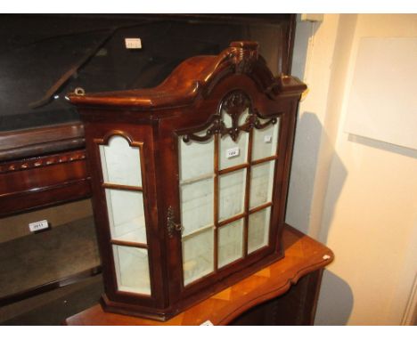 Small mahogany wall cabinet having central bar glazed door enclosing shelved interior, 26ins high, 26ins wide 