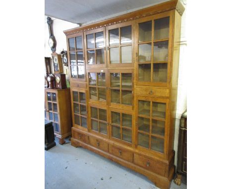 Large mid 20th Century oak bookcase with an arrangement of various small glazed doors and drawers raised on bracket feet7ft h