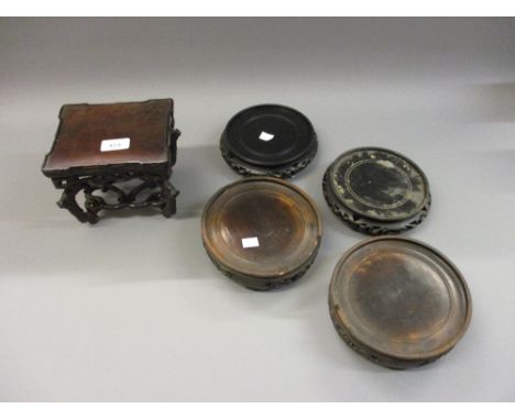 Chinese rectangular carved hardwood vase stand together with four various circular vase standsCondition as shown in photos. 