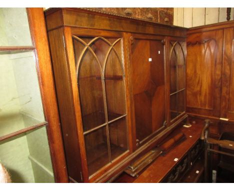 1920's Mahogany bookcase with a moulded top above a centre panelled door flanked by two glazed doors on low splay feet 