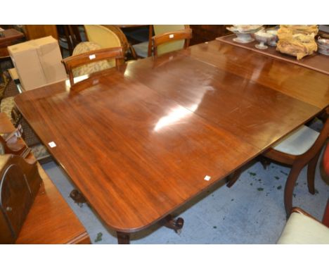 George IV style mahogany three pillar dining table on turned supports with platform bases and scroll feet with two extra leav