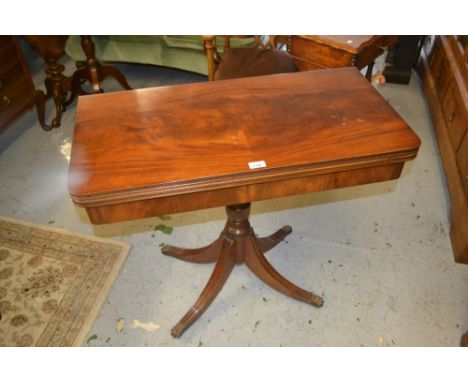 Reproduction mahogany rectangular fold-over card table on a turned column support and quadruped base 
