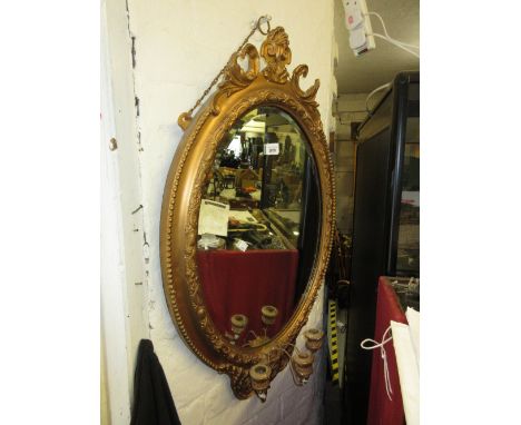 Oval gilt framed bevelled edge wall mirror with triple candle holder bracket 