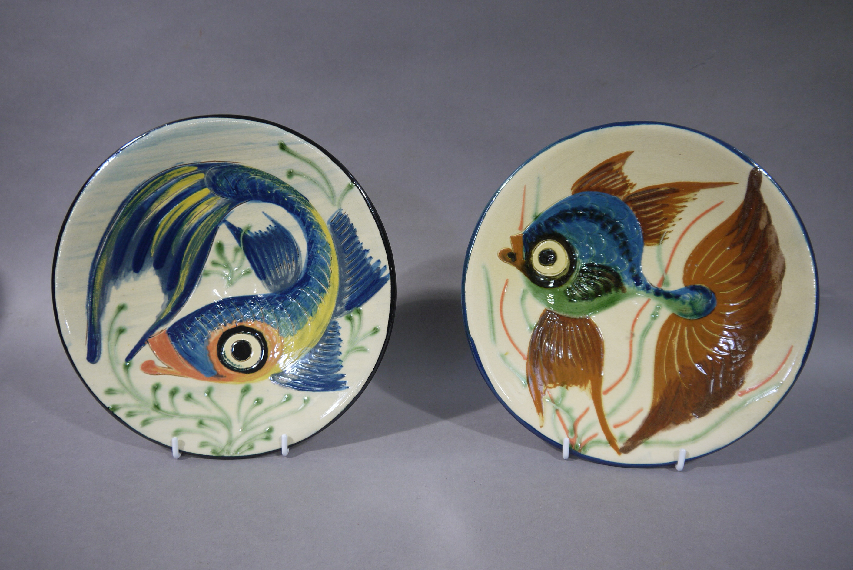 Two continental pottery fish decorated terracotta dishes, 24cm diameter