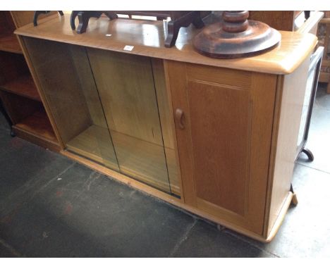 AN ERCOL STYLE SLIDING GLASS BOOKCASE CABINET ON CASTORS   H87CM W137CM D35CM