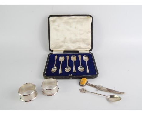 A set of six George V silver coffee spoons, cased, Sheffield 1919, a pair of napkin rings with engine turned decoration, init