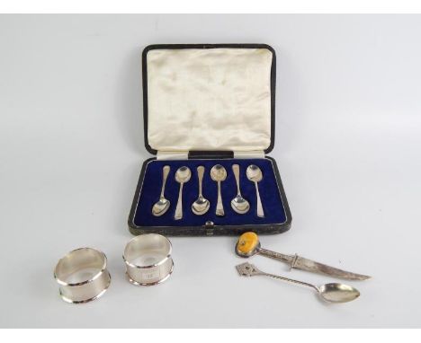 A set of six George V silver coffee spoons, cased, Sheffield 1919, a pair of napkin rings with engine turned decoration, init