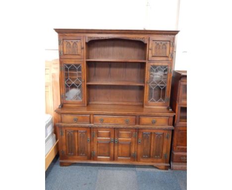 An Old Charm oak dresser, the two shelf delft rack flanked by panelled and astragal glazed doors over three drawers and panel