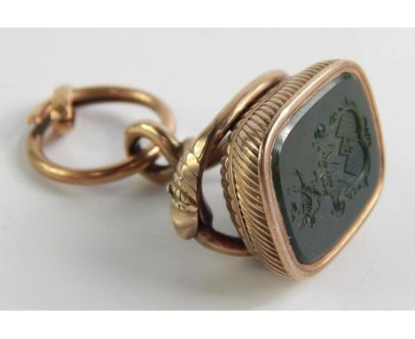 A Victorian yellow metal and bloodstone seal, the rectangular stone intaglio carved with a coat of arms, in a fluted frame, o