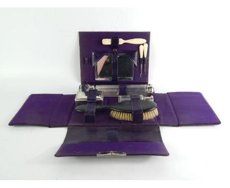 An early 20thC lady's travelling toilet set, comprising hair brush, hand mirror, scent bottle, pin box, hair pin jar, ointmen