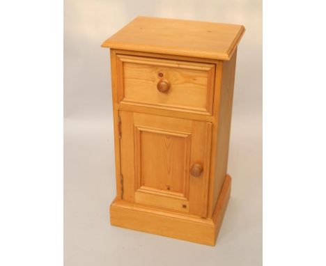 A pine pot cupboard, single drawer over a door enclosing a single shelf, raised on a plinth base, 35.5cm x 29cm x 63cm.