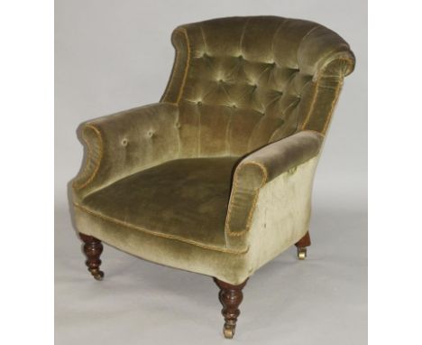 A Victorian armchair, with button back and arms in green material above a shaped seat on turned supports terminating in casto