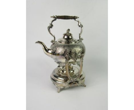 A Victorian electroplate spirit kettle, of compressed circular form engraved with vines, the stand with scroll supports and s