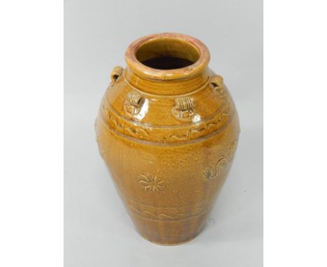 A Chinese ovoid terracotta jar, with ochre glaze and decorated with sgraffito and in relief with pearl and wandering dragon d