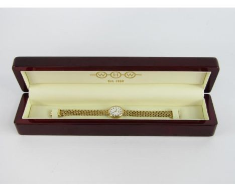 A W H Wilmot 9ct gold cased lady's wristwatch, circular dial bearing Roman numerals, on a gate link strap, boxed, 27.9g total
