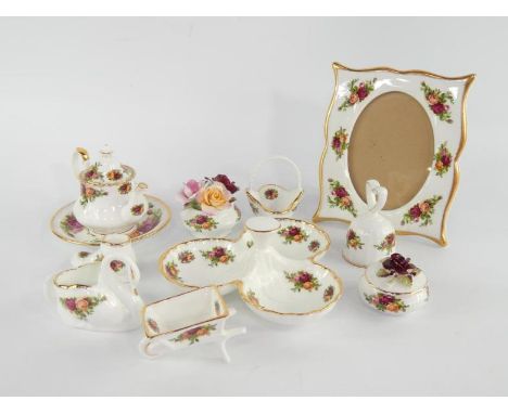 A Royal Albert Old Country Roses porcelain strut photograph frame, hors d'oeuvre dish, spoon dish, miniature teapot and seven