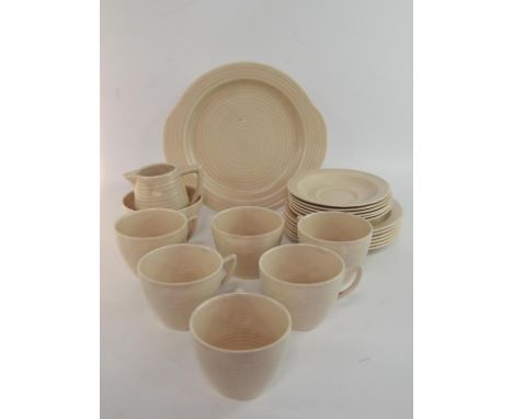 A Clarice Cliff sand coloured part tea service, with horizontal fluting, comprising bread plate, cream jug, sugar bowl, six c