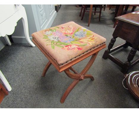 An X-frame stool with tapestry top