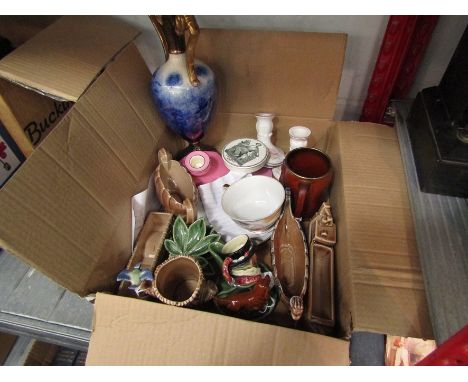 A box containing assorted Wade items, pairs of ceramic candlesticks, pottery jar lid etc