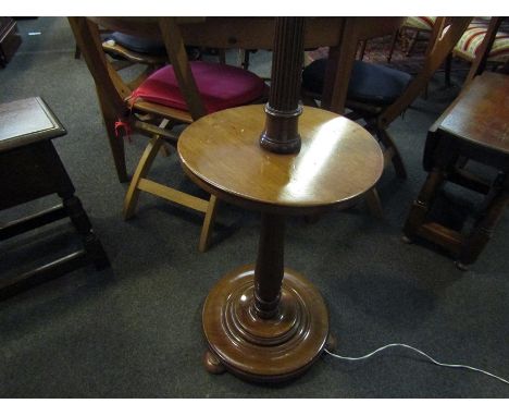 A turned wood standard lamp with integral table tasselled shade