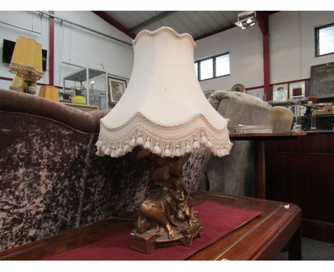 A highly ornate plaster figured lamp base in gilt semi-naked females and putti, 66cm tall with shade