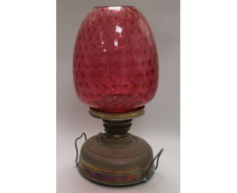 A Victorian brass oil lamp with ruby glass shade