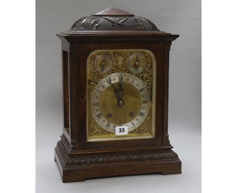 A carved oak mantel clock, with 'ting-tang' chiming movement and brass dial