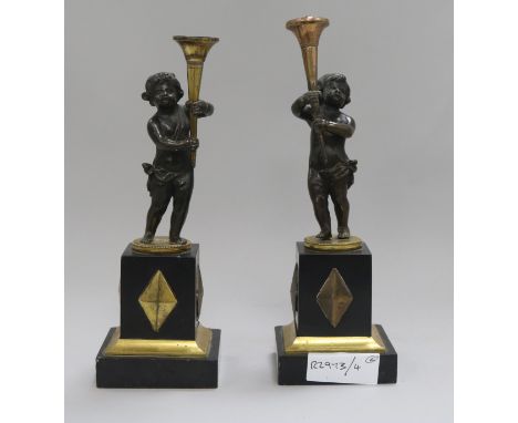A pair of French bronze and gilt metal candlesticks