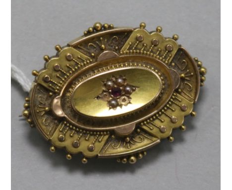 A late Victorian 15ct gold, ruby and seed pearl oval brooch, (2 seed pearls missing) with glazed back, 39mm.